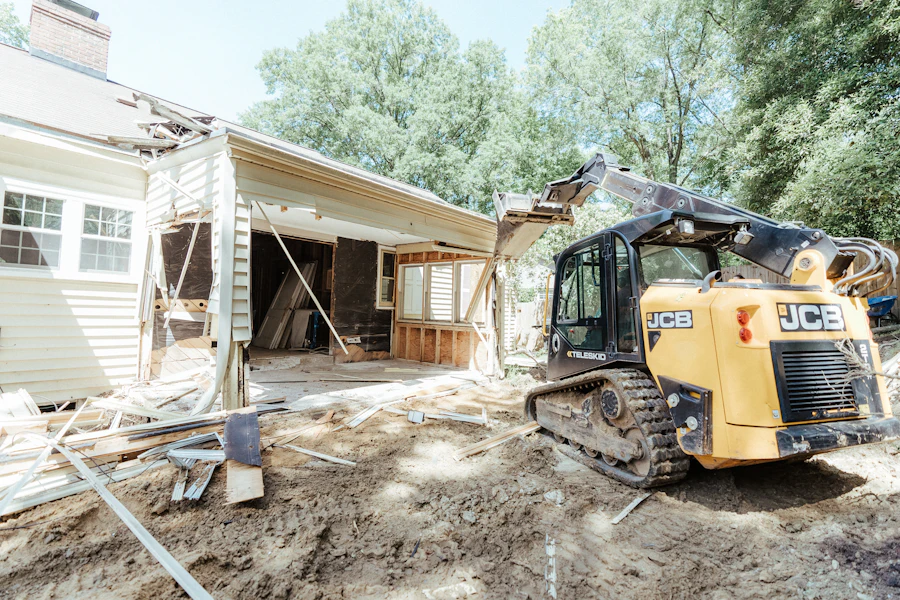 Excavator working beside a demolished structure